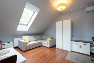 a living room with a white couch and a window at A comfortable apartment midway Kraków-Oświęcim in Chrzanów