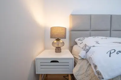 a bed with a night stand with a lamp on it at Green Apartment Chrzanów in Chrzanów