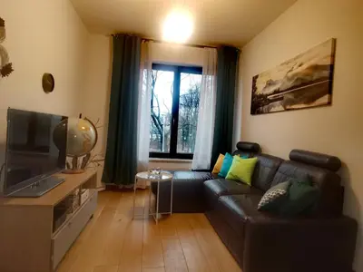 a living room with a leather couch and a television at apart Wilga in Kraków