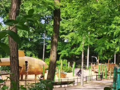 a park with a wooden playground with trees at apart Wilga in Kraków