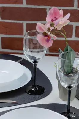 a table with two wine glasses and a flower in a vase at Dąbska Studio with Terrace & Parking by Noclegi Renters in Kraków