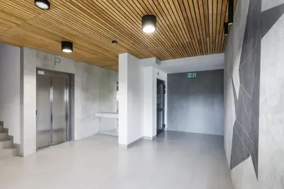 an empty hallway of a building with a wooden ceiling at Dąbska Studio with Terrace & Parking by Noclegi Renters in Kraków