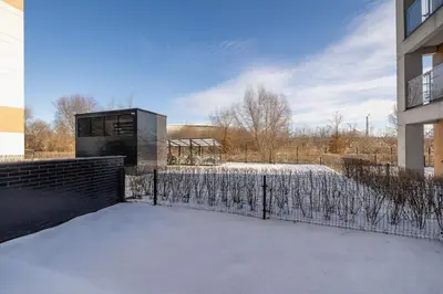 a building with snow on the ground next to a fence at Dąbska Studio with Terrace & Parking by Noclegi Renters in Kraków