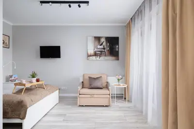 a living room with a couch and a chair at Dąbska Studio with Terrace & Parking by Noclegi Renters in Kraków