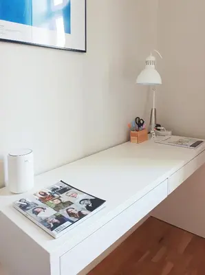 a white desk with a lamp and a magazine on it at Estery Studio Heart of Kazimierz in Kraków