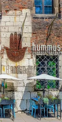 a brick building with tables and umbrellas in front at Estery Studio Heart of Kazimierz in Kraków