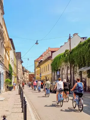 a group of people riding bikes down a street at Estery Studio Heart of Kazimierz in Kraków