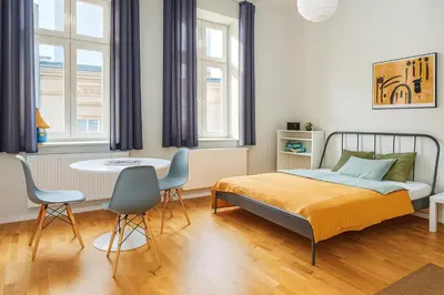 a bedroom with a bed and a table and chairs at Estery Studio Heart of Kazimierz in Kraków