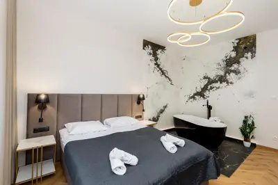 a bedroom with a bed and a bath tub at SPA bedrooms with Sauna&Bath and Free Parking in Kraków