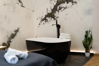 a bathroom with a black and white bath tub at SPA bedrooms with Sauna&Bath and Free Parking in Kraków