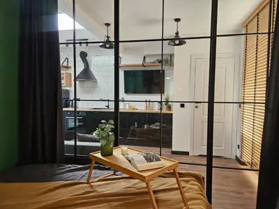 a room with a bed and a table with a book at Cracovia Luxury Bright Apartment Great Location Sauna in Kraków