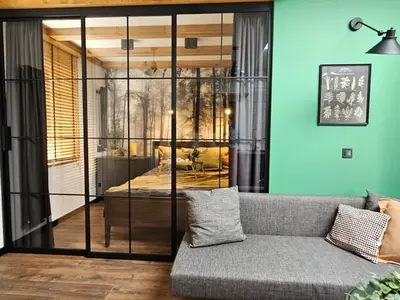 a living room with a couch and a glass wall at Cracovia Luxury Bright Apartment Great Location Sauna in Kraków