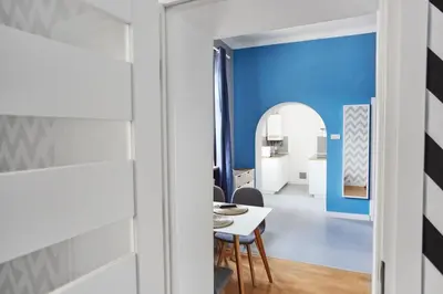 a room with blue walls and a table and chairs at Smart Old Town Apartment in Kraków