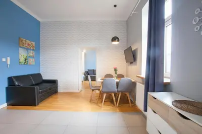 a living room with a black couch and a table at Smart Old Town Apartment in Kraków