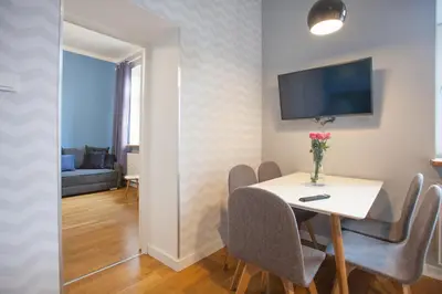 a dining room with a table with chairs and a tv at Smart Old Town Apartment in Kraków