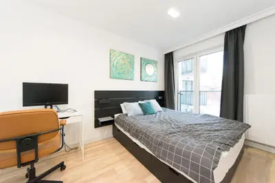 a bedroom with a bed and a desk and a television at Ghetto Heroes Square Lwowska 10 A/C p4you pl in Kraków