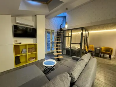 a living room with a couch and a tv in a room at Balcony Bliss Main Square Loft in Kraków