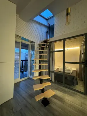 a spiral staircase in a room with a bedroom at Balcony Bliss Main Square Loft in Kraków