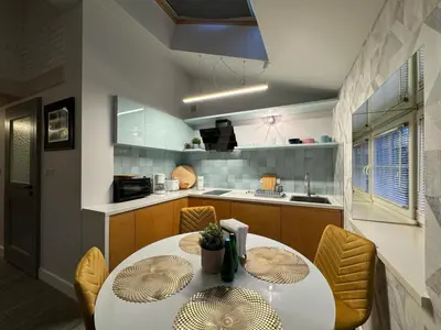 a kitchen with a table and chairs in a kitchen at Balcony Bliss Main Square Loft in Kraków