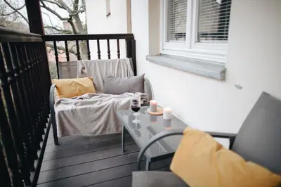 a small balcony with a table and a window at Balcony Bliss Main Square Loft in Kraków