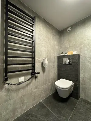 a bathroom with a white toilet in a room at Balcony Bliss Main Square Loft in Kraków