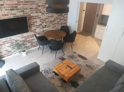 a living room with a wooden table and chairs at Apartament nad Wisłą, bezpłatny parking, AWG APARTMENTS in Kraków
