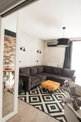a living room with a couch and a table at Apartament nad Wisłą, bezpłatny parking, AWG APARTMENTS in Kraków