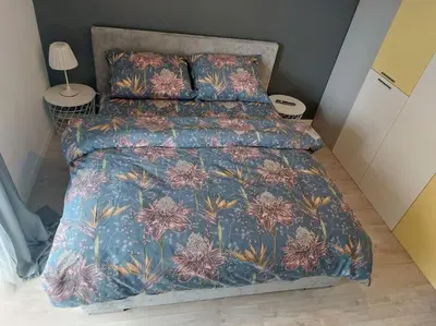 a bedroom with a bed with a floral comforter at Apartament nad Wisłą, bezpłatny parking, AWG APARTMENTS in Kraków