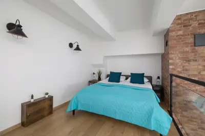 a bedroom with a bed and a brick wall at Deluxe Loft Apartment Lubelska with Mezzanine by Noclegi Renters in Kraków