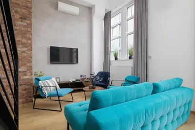 a living room with a blue couch and chairs at Deluxe Loft Apartment Lubelska with Mezzanine by Noclegi Renters in Kraków