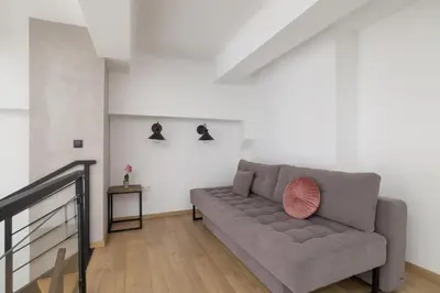a living room with a couch and a table at Deluxe Loft Apartment Lubelska with Mezzanine by Noclegi Renters in Kraków