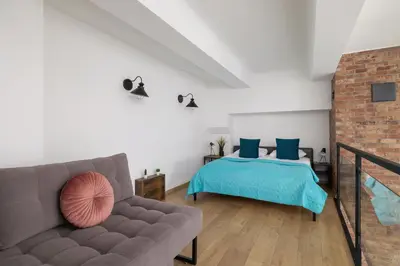 a living room with a couch and a bed at Deluxe Loft Apartment Lubelska with Mezzanine by Noclegi Renters in Kraków