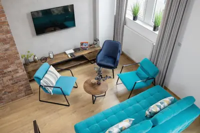 a living room with a blue couch and chairs at Deluxe Loft Apartment Lubelska with Mezzanine by Noclegi Renters in Kraków
