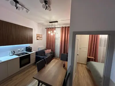 a room with a kitchen and a living room at New comfortable apartment with patio on Klimeckiego street in Kraków
