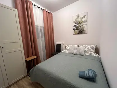 a small bedroom with a bed and a window at New comfortable apartment with patio on Klimeckiego street in Kraków