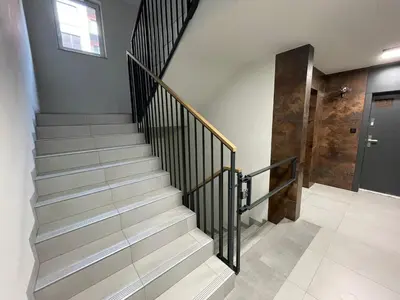 a staircase with a black rail and a door at New comfortable apartment with patio on Klimeckiego street in Kraków