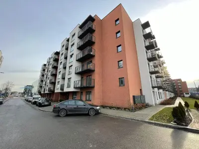 a car parked in front of a tall building at New comfortable apartment with patio on Klimeckiego street in Kraków