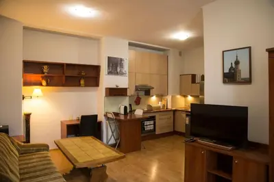 a living room with a couch and a kitchen at Kompleksowo wyposażony apartament w centrum in Kraków