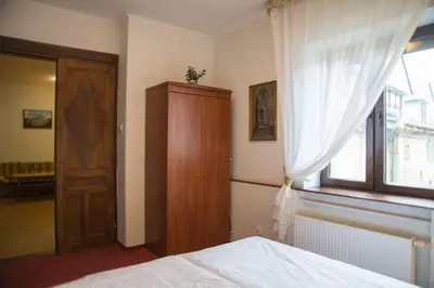 a bedroom with a bed and a wooden cabinet and a window at Kompleksowo wyposażony apartament w centrum in Kraków