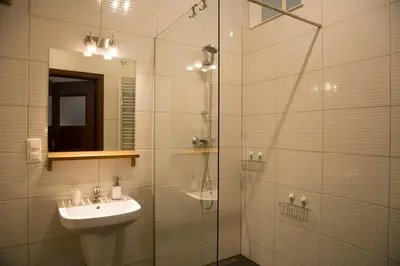 a bathroom with a sink and a glass shower at Kompleksowo wyposażony apartament w centrum in Kraków