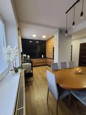 a kitchen and dining room with a table and chairs at Domek Bocianie Gniazdo in Stradomka