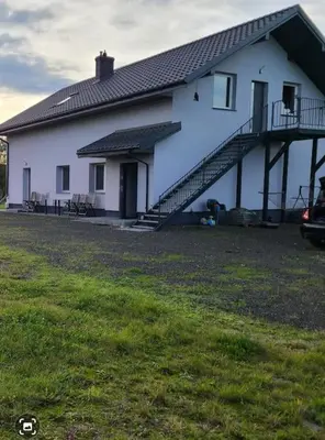 a white house with a staircase on the side of it at Domek Bocianie Gniazdo in Stradomka