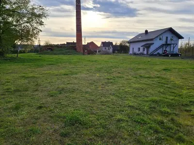 a white house in a field with a silo at Domek Bocianie Gniazdo in Stradomka
