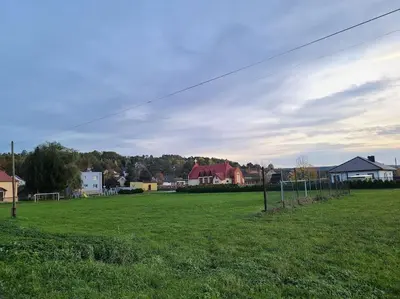 a green field with a soccer field with houses at Domek Bocianie Gniazdo in Stradomka
