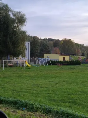 a park with playground equipment in a green field at Domek Bocianie Gniazdo in Stradomka