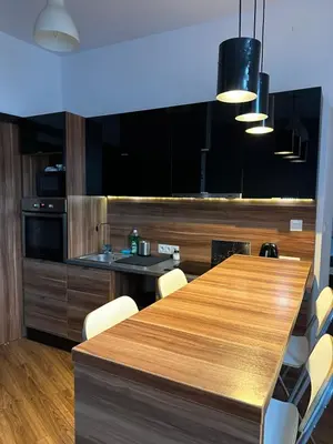 a kitchen with a long wooden table and chairs at City Center Apartment in Kraków