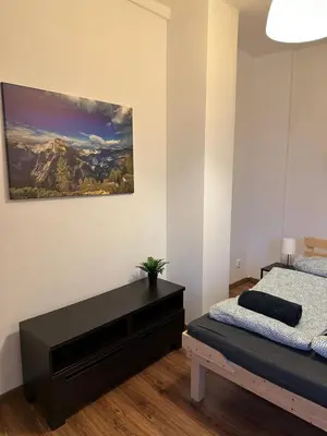 a bedroom with a bed and a black dresser at City Center Apartment in Kraków