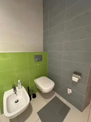 a bathroom with a white toilet and a sink at City Center Apartment in Kraków