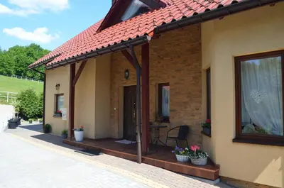 a patio of a house with a roof at Gospodarstwo Agroturystyczne Stajnia Grudki Energylandia Zator in Zator