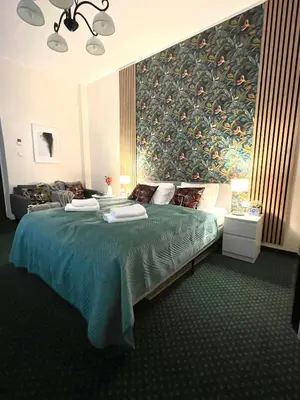 a bedroom with a large bed with a painting on the wall at Gertrudy 10 Residence - 1-Minute Walk to the Old Town in Kraków